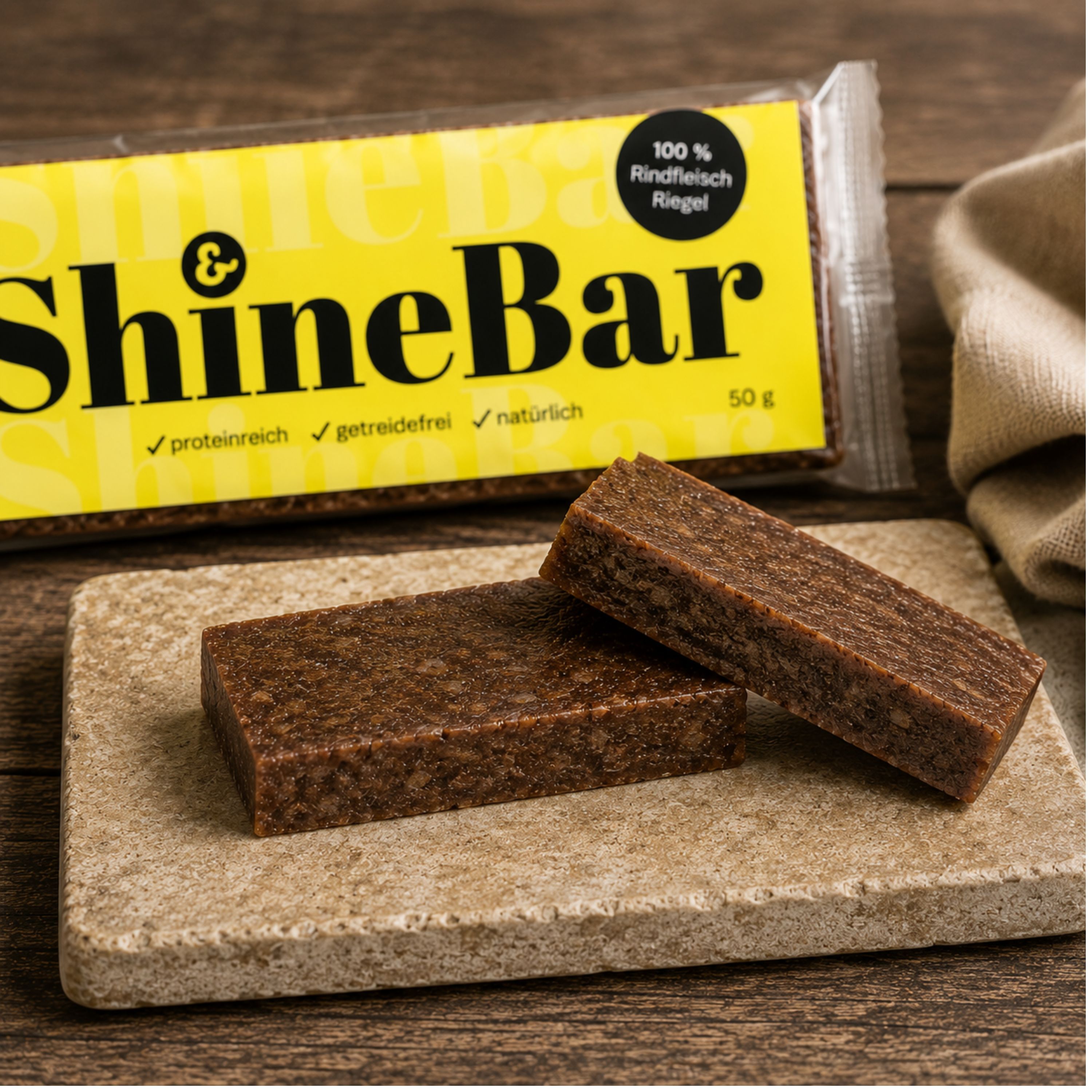 Aufgeschnittener ShineBar Belohnungsriegel aus Rind mit fester Struktur auf Natursteinplatte