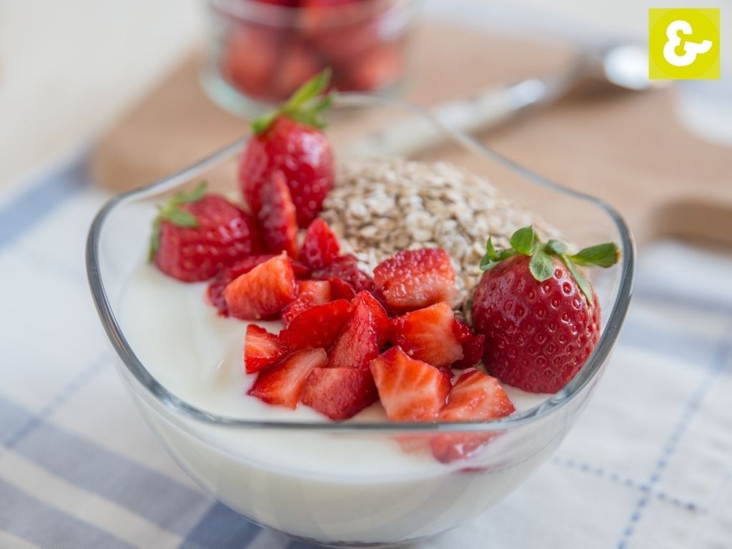 Naturjoghurt mit Erdbeeren garniert in einer Glasschüssel